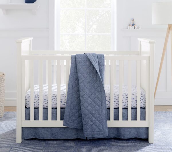 CozyCradle Convertible Crib in a white finish, featuring clean lines and a timeless design. The crib is set in a cozy nursery with soft bedding, offering a safe and stylish sleeping space for babies. This crib can be converted into a toddler bed as your child grows, combining functionality and elegance.