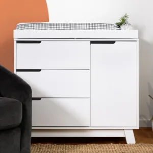 DreamNest 3 Drawer Dresser & Topper Set with Mid-Century design, rounded feet, cutout handles, three drawers, storage cabinet, and changing table topper.