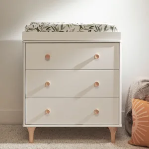 DreamNest Lolly 3 Drawer Dresser & Topper Set in a modern nursery setting, showcasing its sleek design and ample storage space.