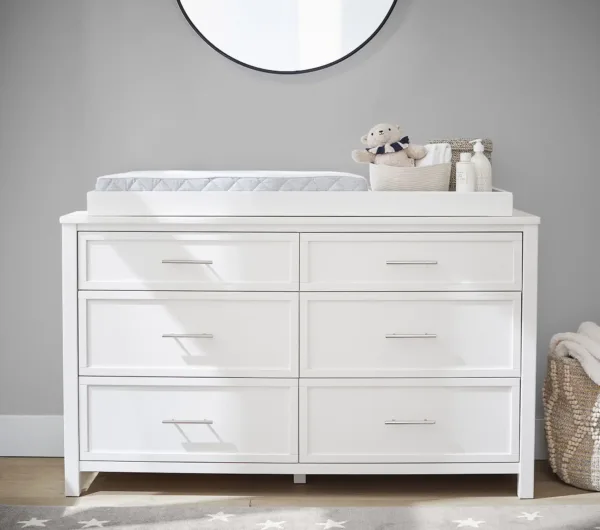 Dreamland Extra Wide Dresser & Topper Set in a nursery, showcasing its spacious design with multiple drawers and a removable changing topper.